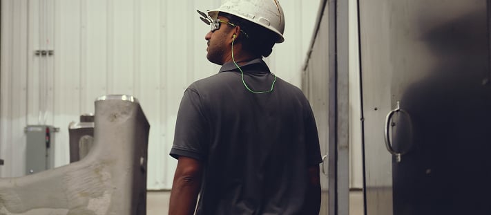 A worker in a white construction hat inspects recent developments.